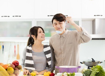 happy asian couple cooking in the kitchen