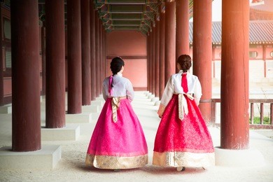 asian korean woman dressed hanbok in traditional dress walking in gyeongbokgung palace in seoul, south korea.

