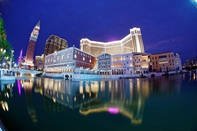 night scenery of the extravagant exterior of the venetian macau, a luxury hotel & casino resort in macao, china, with reflections of beautiful buildings and colorful neon lights in the water