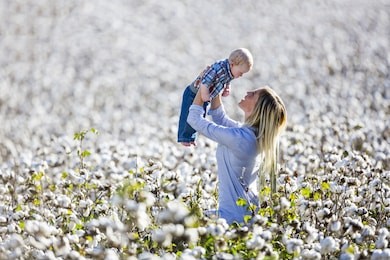 a young mother and her child enjoying a fall day in a cotton field