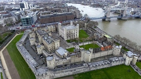 aerial view flying over tower of london wall castle with tower bridge and river thames in england, uk