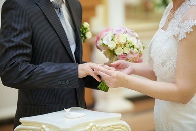 the bride and groom put the ring on the wedding ceremony
