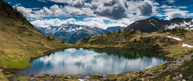 wide panoramic vista over tristaina lake in pyrenees,andorra