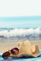 concept of summer holidays with straw hat and sunglasses on sandy beach