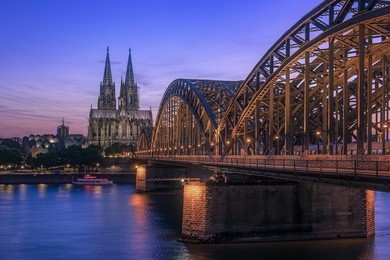 sunset sky with colors and clouds over the city skyline cologne with bridge and köln dom ,evening scene over cologne/koln city with kolner dom/cathedral behind the hohenzollern bridge 