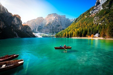 amazing view of braies lake with wooden boats on the water, surrounded by dolomites mountains. trentino alto adige, italy