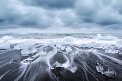 picturesque landscape with iceberg pieces on diamond beach near jokulsarlon lagoon, iceland. atlantic ocean view
