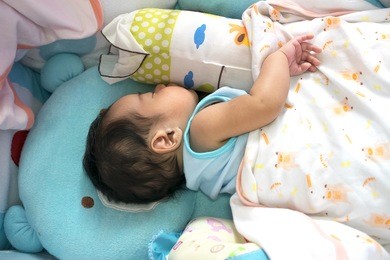 asian baby sleeps in the crib