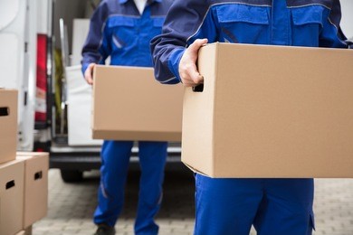 close-up of two mover's hand in uniform carrying cardboard box