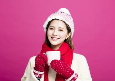 woman in warm sweater drinking a cup of hot tea
