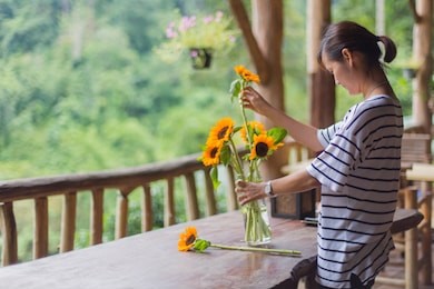 asian women are arranging flowers in a vase.