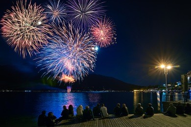 crowd watching fireworks and celebrating. beautiful firework display for celebration on the garda lake,italy,brightly colorful fireworks