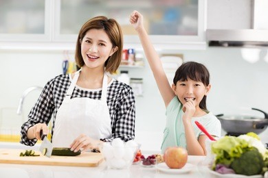happy mother and daughter cooking in the kitchen
