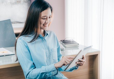 asian businesswoman use tablet to online conference meeting with smiling face,happy office life concept,working woman at modern home office