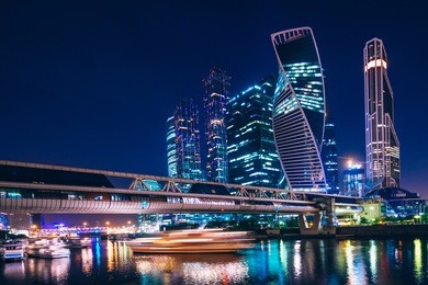 business center with skyscrapers of moscow-city at night under the blue sky and with reflections of the illumination on the water. cityscape