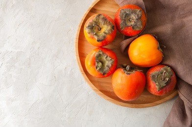 plate of fresh and ripe persimmons. top view and copy space.
