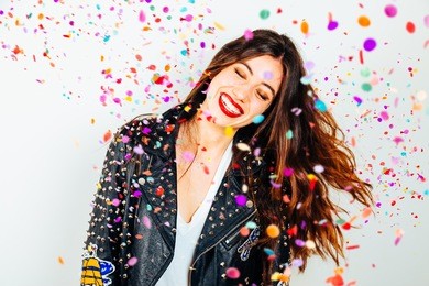 happy young and beatiful woman with fashion leather jacket enjoying the party with confetti
