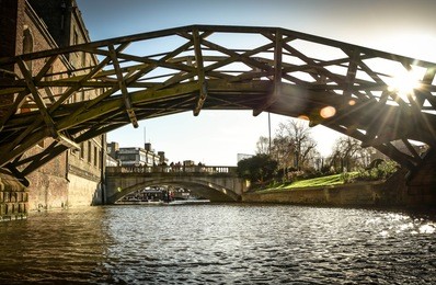 cambridge famous and historical wooden bridge over cam river with sunlight through the bridge. mathematical bridge,cambridge, england, united kingdom. cambridge university icon
