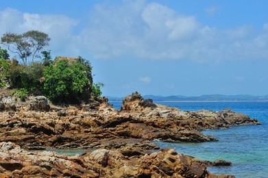 tropical island. a part of beautiful kapas island, malaysia with unique formation rocks, reflection and blue sky,