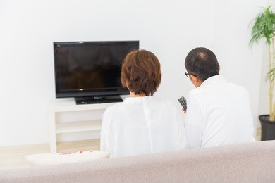 asian senior couple watching tv in living room,back figure