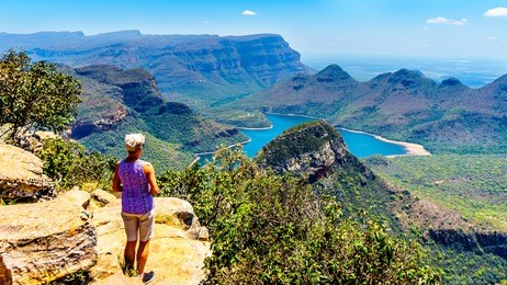 senior woman enjoying the view of the blyde river canyon and blyde river dam from the highveld viewpoint along the panorama route in mpumalanga province of south africa