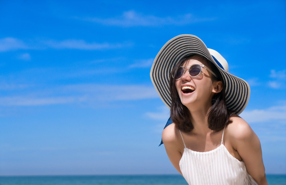 portrait of happy smiling woman on the beach on a beautiful . pretty girl asian in casual looking away and smile , laughing. the beach beautiful at bright sky