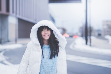 beautiful asian girl waking in the street with snow background