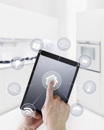 home automation hand touch screen digital tablet with symbols on kitchen blurred background 