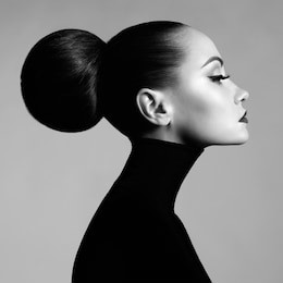 black and white fashion art studio portrait of beautiful elegant woman in black turtleneck.  hair is collected in high beam.  elegant ballet style