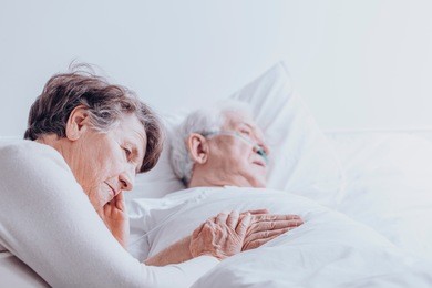 sad senior woman taking care of her dying husband with alzheimer's disease at the hospital
