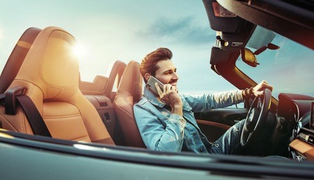 young handsome man posing in a convertible car