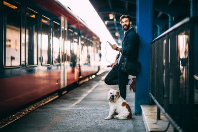 young man using mobile phone at train station