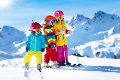 child skiing in the mountains. kid in ski school. winter sport for kids. family christmas vacation in the alps. children learn downhill skiing. alpine ski lesson for boy and girl. outdoor snow fun.