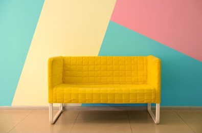 comfortable armchair near color wall