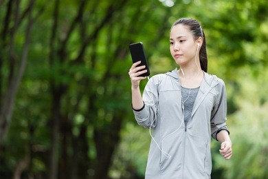 attractive asian woman jogging in park