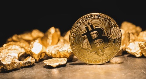 cryptocurrency bitcoin and mound of gold nuggets - business concept image
