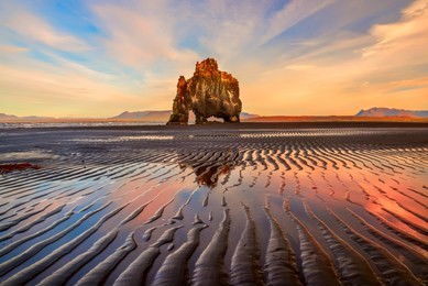 rock on the shore of the ocean of an interesting unusual shape at low tide. interesting symmetrical lines on the sand. iceland. sea landscape. places of interest. rock  hvitserkur

