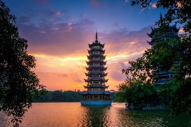 beautiful sunrise with colorful sky at guilin's sun and moon twin pagodas (one of the guilin's attractions) in shanhu (shan lake), guangxi, guilin china.