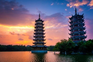 beautiful sunrise with colorful sky at guilin's sun and moon twin pagodas (one of the guilin's attractions) in shanhu (shan lake), guangxi, guilin china.