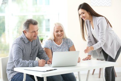 female insurance agent consulting senior couple in office