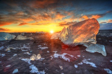 beautiful sunset over famous diamond beach, iceland. this sand lava beach is full of many giant ice gems, placed near glacier lagoon jokulsarlon.