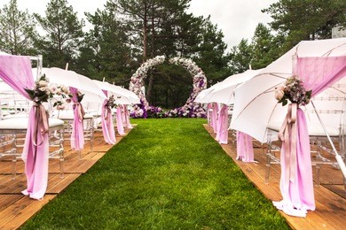 outdoor wedding ceremony with umbrellas in the forest.