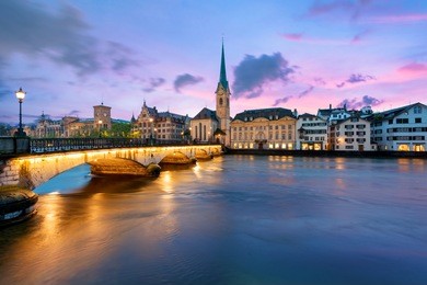 panoramic view of historic zurich city center with famous fraumunster church and river limmat at lake zurich , in twilight, canton of zurich, switzerland.