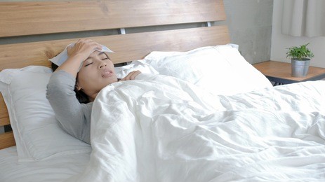 woman get sick and fever lying on the bed