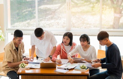 asian college groups of students using laptop, tablet, studying together with notebooks documents paper for report near windows in classroom. happy young study for school assignment, education concept