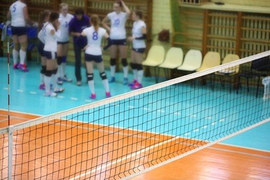 volleyball net in the sport hall with players on background