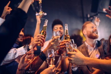 group of friends cheering with champagne and beer