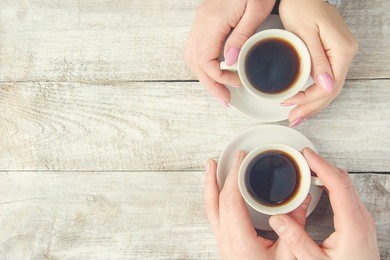 cups with a coffee in the hands of men and women. selective focus.