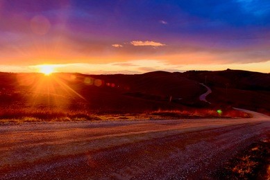 endless road on the desert hills at sunset