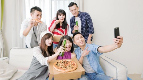 young people eat pizza and selfie happily with party